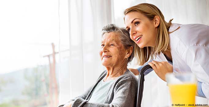 Pflegerin mit Seniorin in Rollstuhl