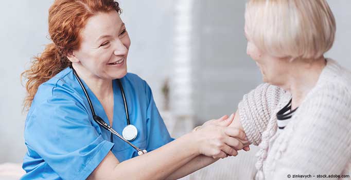 Pflegerin misst Blutdruck bei Seniorin